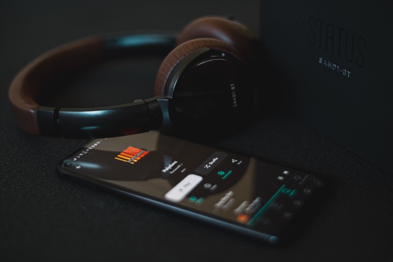 Headphones and smartphone with podcast audio streaming app open