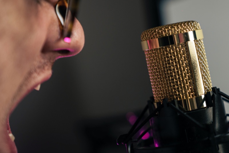 Person shouting into podcast microphone stock image