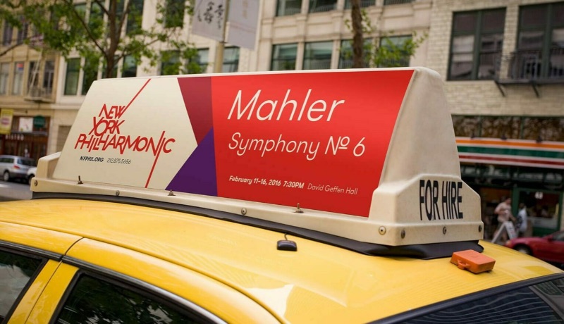 OOH taxi ad for the New York Philharmonic featuring their logo graphic by MetaDesign