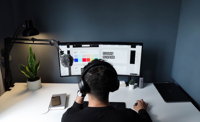 Person with headphones doing graphic design on their desktop