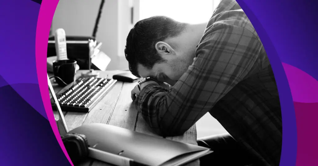 man with his head down on a desk