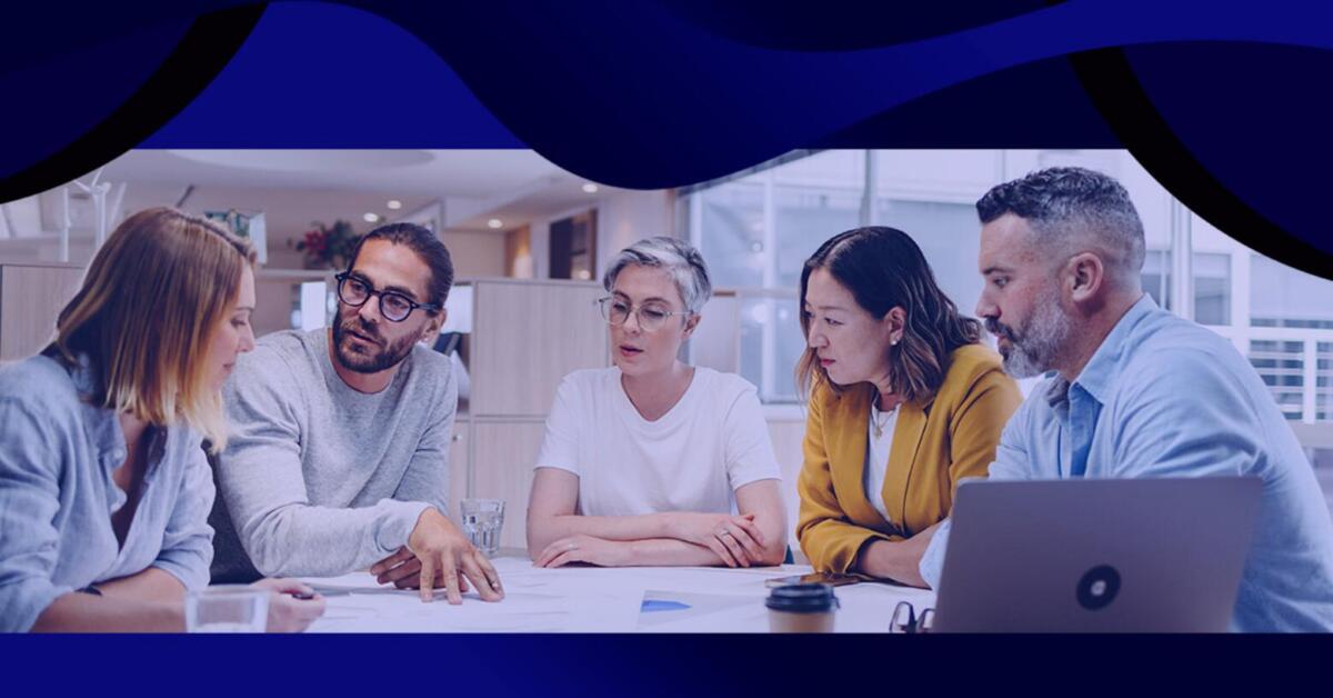 Agency creative team reviewing graphic design services on a desktop with branded client assets